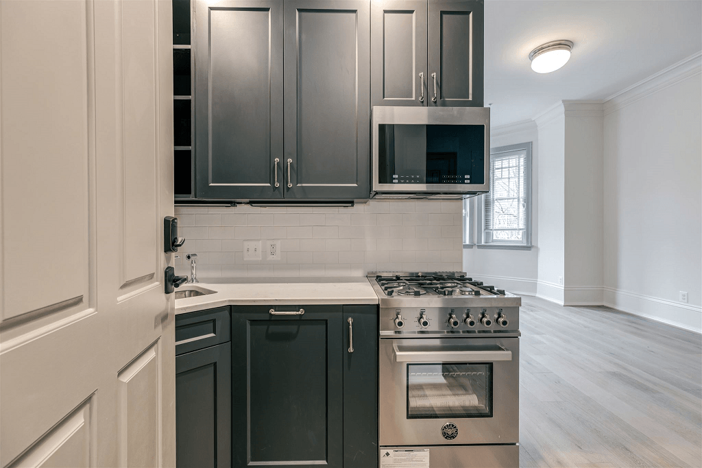 a kitchen with black and white cabinets and a stove
